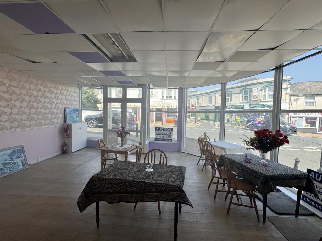 Lot: 22 - PROMINENT TOWN CENTRE VACANT COMMERCIAL UNIT - View towards main road with wooden tables and chairs